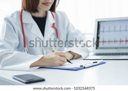Female doctor working on desk with laptop