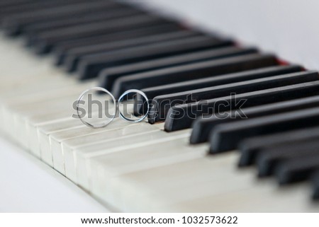 Wedding rings on the piano keys. Close-up.