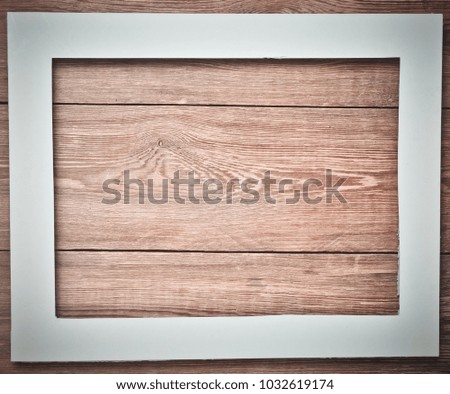 White frame on a wooden surface. Copy space.
