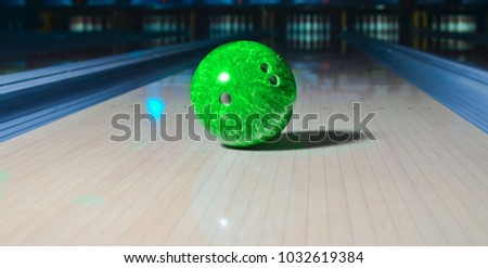 Bowling ball put on alley with blurred bowling pin background. 