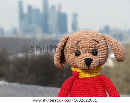 Knitted toy dog on the Moscow city background