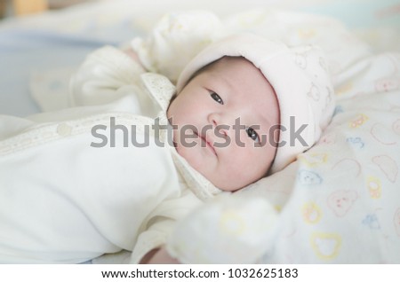Portrait of cute asian baby looking on bed