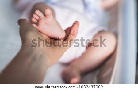 Newborn baby feet in mother hand. Mom and her Child.