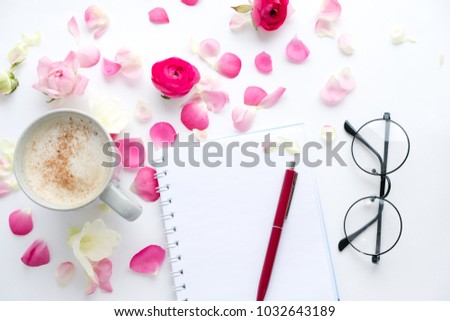 Cup of coffee with pink roses and flowers. Flat lay, top view. retro glasses and a notebook on the desktop. spring, international women's day