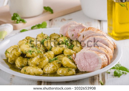 Pork tenderloin with herbs and spices, pesto gnocchi, food photography