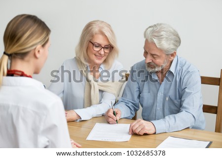 Aged couple signing contract making investment at meeting with financial advisor, happy senior family put signature on business document taking bank loan, retired smiling customers buying insurance