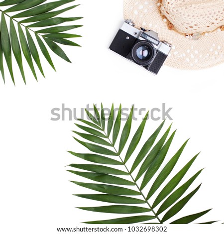 Palm leaves, straw hat and photo camera isolated on white background. Flat lay travel concept.