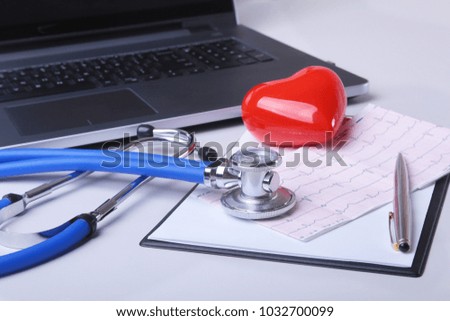 Workplace of doctor with laptop, stethoscope, RX prescription, glasses and red heart and notebook on white table. top view. Copy space.