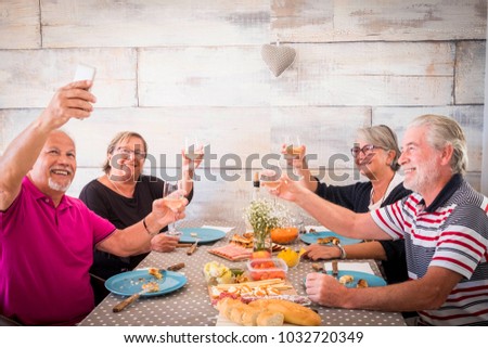 4 senior people two man and two women taking selfie at the table