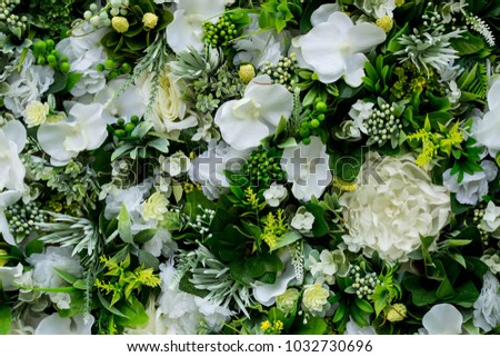 Colorful floral background of white eustoma, hydrangeas, other flowers, leaves and decorative branches.  Festive design of premises. Painting from flowers on wall