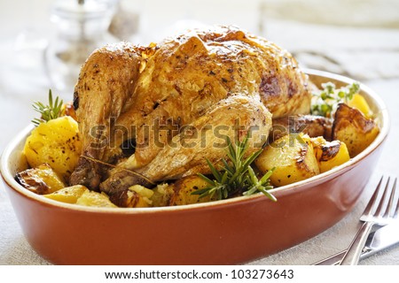 Photograph of a tasty roasted chicken with potatoes