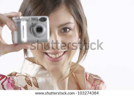 Close up portrait of a teenager taking a picture with her digital camera.