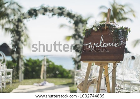 Romantic wedding ceremony on the beach. Sign welcome.