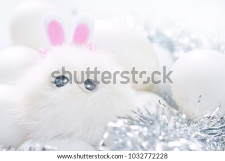 Happy Easter Day concept. Cartoon rabbit with eggs in nest. High key toned image and free space for text.