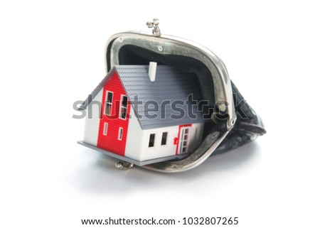 Savings concept. House in leather wallet isolated on white background

