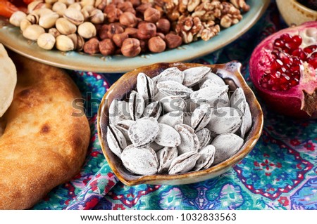 Traditional Azerbaijan sweet cuisine of holiday Nowruz: apricot bones fried with salt in ashes, lavash bread, assortment of nuts and dry fruits. Close-up