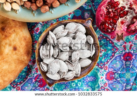 Traditional Azerbaijan sweet cuisine of holiday Nowruz: apricot bones fried with salt in ashes, lavash bread, assortment of nuts and dry fruits. Close-up