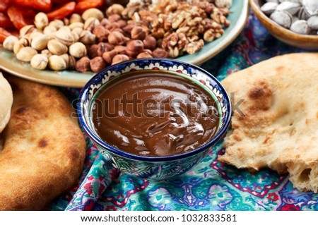 Traditional Azerbaijan sweet cuisine of holiday Nowruz: national dessert called Sumalak, lavash bread, halva, assortment of nuts and dry fruits. Close-up