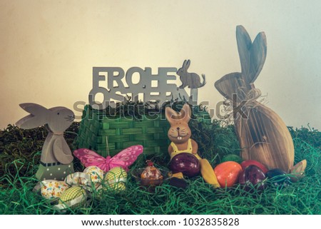 Easter holidays - a party for the whole family. Motif with Easter symbols, colorful eggs, butterflies, rabbits, grass and birds. The text says in German: Happy Easter. Concept: Easter and holiday
