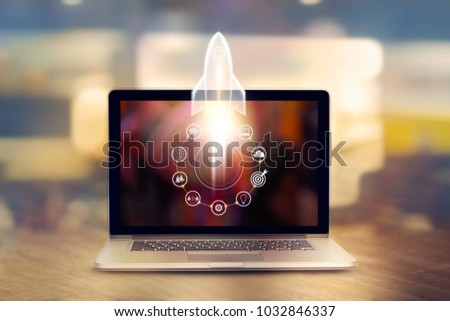Startup concept. Laptop on wooden table and and icon network connection with rocket icon flying out of screen  Royalty-Free Stock Photo #1032846337