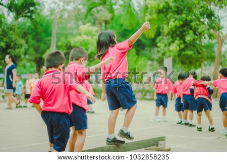 Happy Kindergarten students are exercising in morning.