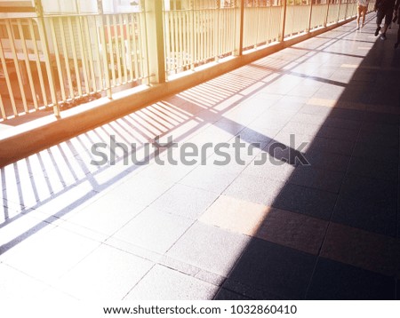 Light and shadow evening on the floor of skywalk pathway at skytrain station in Bangkok, Thailand.