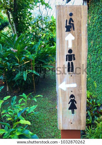 Signs for directions to the toilet (men, women). Signs are made Installed near the tree.