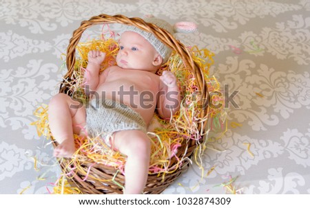 newborn baby girl laying in Easter basket wearing handmade knit bunny outfit