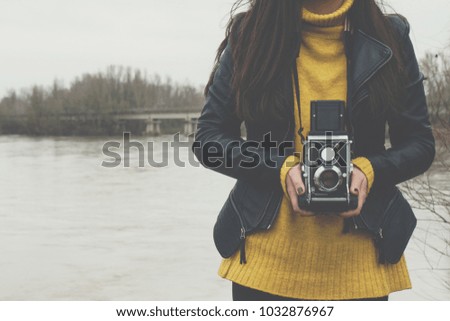 Young woman taking photographs with vintage retro camera