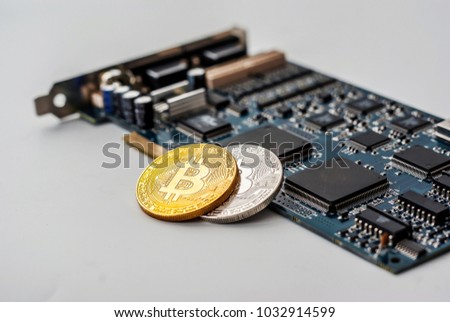 Coins Bit-coin on the background of an electronic board with chips.