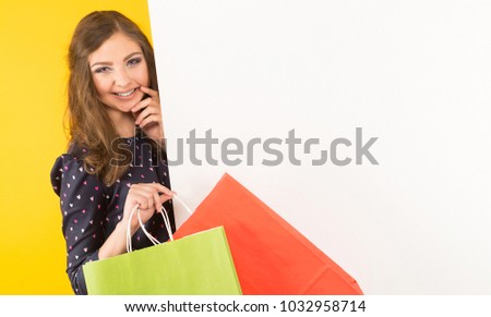 Attractive woman with banner and shopping bags