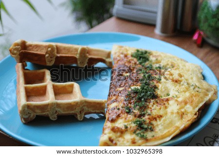 Breakfast. Omelette with herbs and waffles.