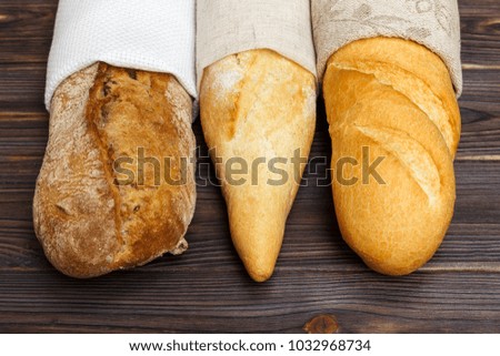 Homemade baguettes on wooden table. close up.