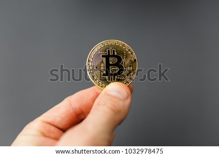 bitcoin in hand, coin bitcoin on the table, a lot of free space