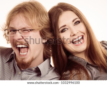 Ginger nerdy man and beautiful teen woman having fun together posing for picture.