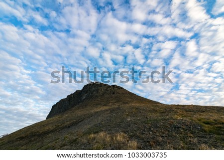 Beautiful clouds above Platafjellet in summer. Rocky hills with some vegetation. Photo taken at midnight, scene lightened by the midnight sun.