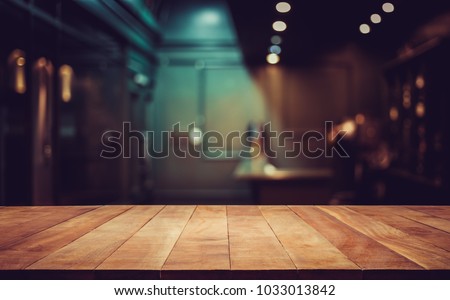 Wood table top on blurred of counter cafe shop with light bulb background.for montage product display or design key visual layout.