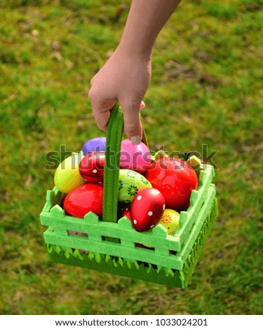 Woman hand holding nest with Easter eggs