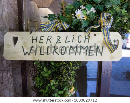 Herzlich willkommen sign translates into Welcome in English