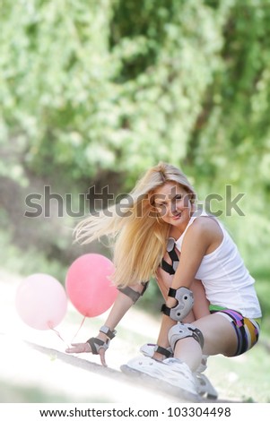 young woman enjoying rollerblading / roller skating on natural background