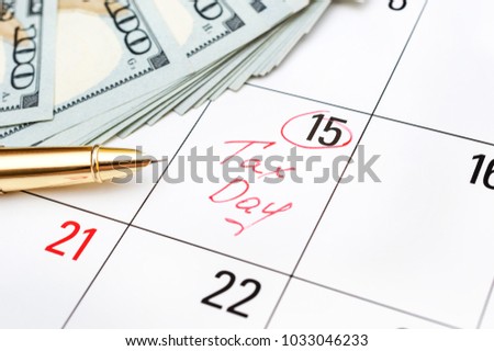 Tax day written on calendar and money. Close up. 