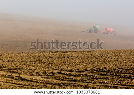 Beautiful misty foggy autumn landscape with working tractor in south moravia, Czech Republic. Agriculture concept.