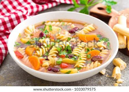 Minestrone soup. Vegetable soup with fresh tomato, celery, carrot, zucchini, onion, pepper, beans and pasta. Dish of italian cuisine.
