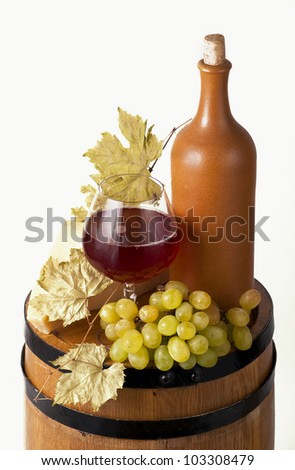 Still life with wine bottles, glasses and oak barrels