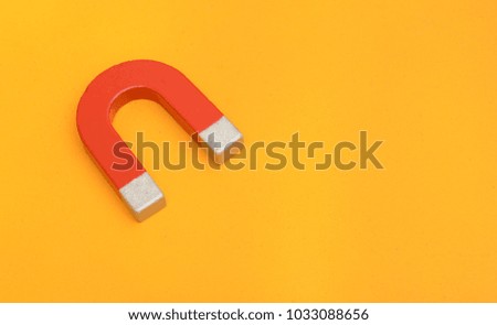 Red Magnet metal on yellow background education concept