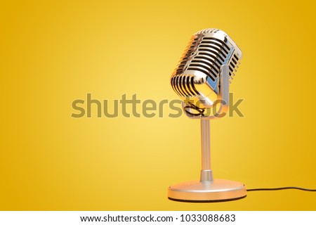 Retro vintage microphone on yellow background studio
