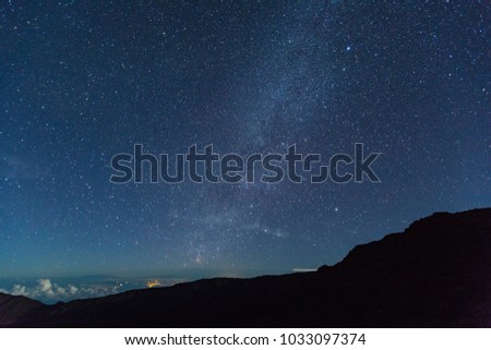 stars against the dark sky with clouds shot from the summit of haleakala national park and haleakala crater on the island of maui in the hawaiian islands in the pacific ocean showing the milky way