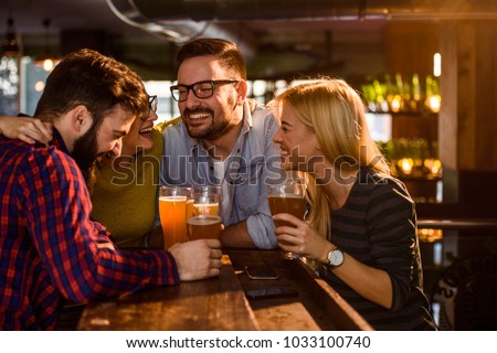 Friends in the Pub. Drinking beer, talking, having fun. Royalty-Free Stock Photo #1033100740