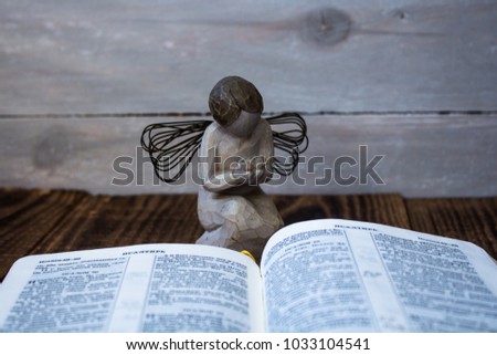 angel and bible on a wooden background
