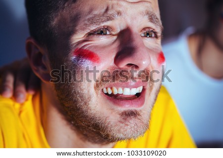 Sad, disappointing football fan crying, closeup 